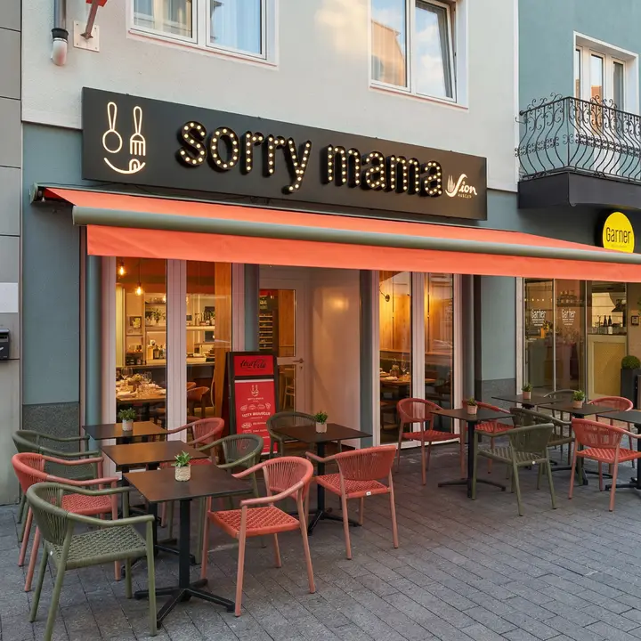Terrasse von Sorry Mama mit orangefarbener Markise in der Kölner Innenstadt