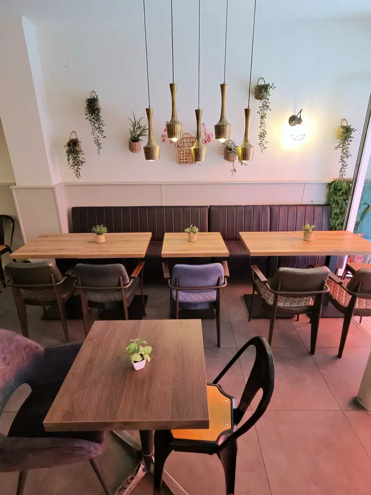 Gedeckte Tische im Restaurant Sorry Mama nahe Kölner Dom mit warmem Licht und Pflanzen